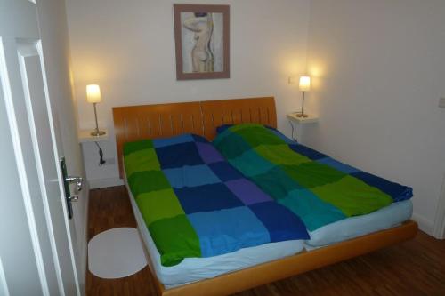 a bed with a colorful blanket on it in a room at Ferienwohnung Meding am See in Schondorf am Ammersee