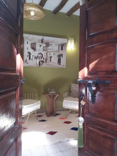 a room with two chairs and a table and a door at Riad Les Nuits de Marrakech in Marrakech