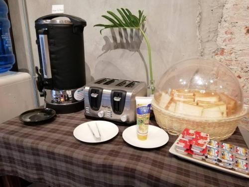 a table with a coffee maker and a plate of food at Aen Guy Boutique Hotel in Sukhothai