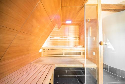 a sauna with a wooden floor and a glass wall at Romantik Hotel Walhalla in Osnabrück