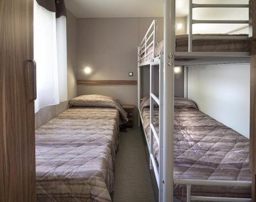 グラードにあるVillaggio Turistico Europaの二段ベッド2組が備わるドミトリールームのベッド2台分です。