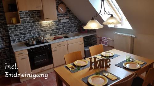 a kitchen with a wooden table with chairs and a dining room at Kansteinblick Weserbergland in Salzhemmendorf