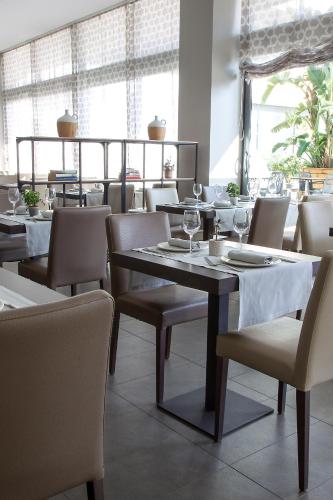 a dining room with tables and chairs with wine glasses at Altafulla Mar Hotel in Altafulla