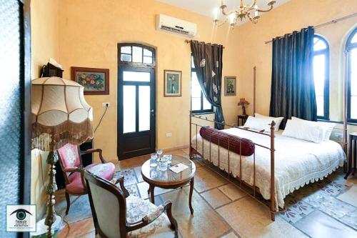 sypialnia z łóżkiem, stołem i krzesłami w obiekcie Atelier Luxury Rooms w mieście Hajfa