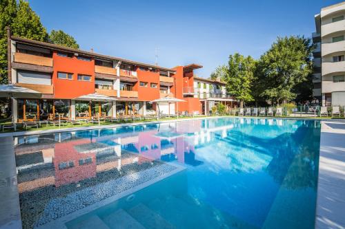 uma piscina em frente a um edifício em Hotel La Pergola em Lignano Sabbiadoro