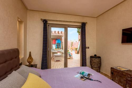 a bedroom with a bed and a view of a patio at Amyour Roa in Mirleft