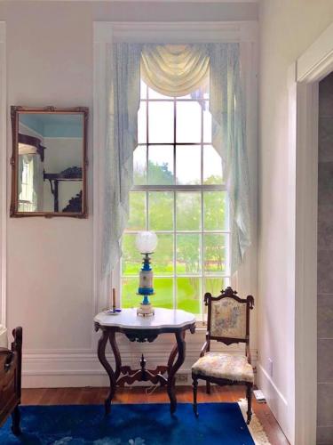 a living room with a table and a window at The Montgomery B&B in Starkville