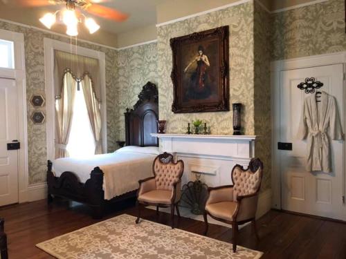 a bedroom with a bed and two chairs at The Montgomery B&B in Starkville