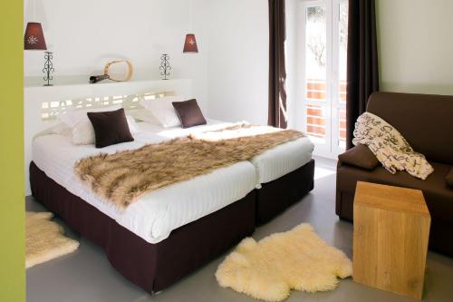 1 dormitorio con 1 cama grande y 1 sofá en Logis Du Puy Ferrand, en Le Mont-Dore