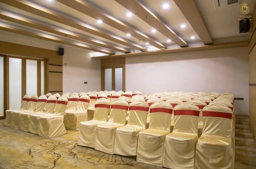 a room with rows of white chairs in it at KPM TRIPENTA HOTEL in Kozhikode