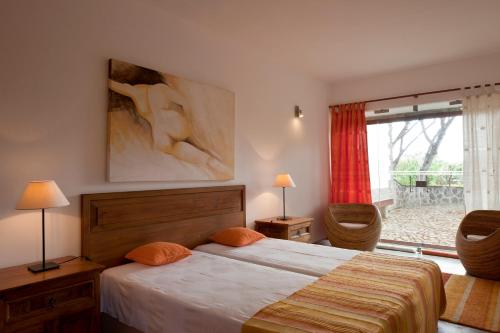 a bedroom with a bed and a large window at Solar Do Magoito in Sintra