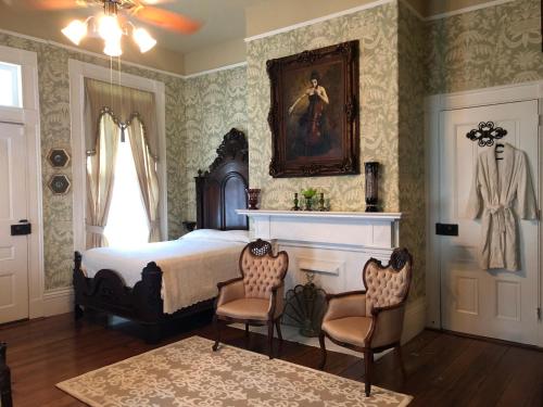 a bedroom with a bed and two chairs at The Montgomery B&B in Starkville