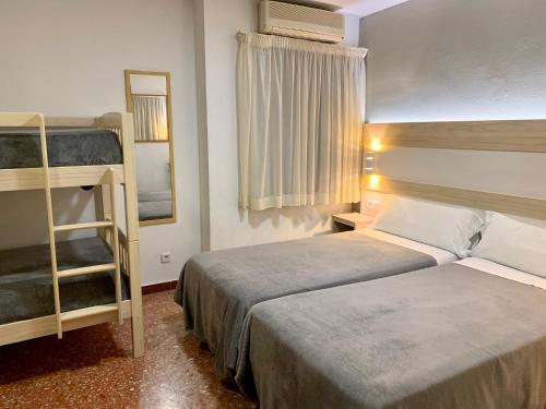 a hotel room with two beds and a bunk bed at Hotel Catalunya Express in Tarragona
