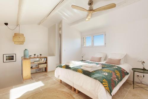 a bedroom with a bed and a ceiling fan at Domaine Les Petites Vaines in Goult