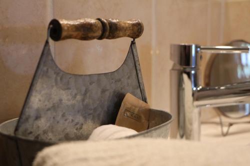 a metal bowl with a hammer on top of it at Chambres et Gîte PEYROUTAS " CAMILLE" Vignonet St Emilion in Vignonet