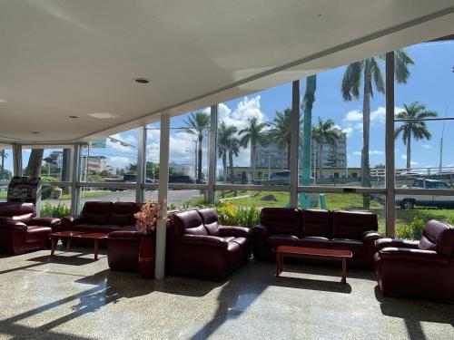 a lobby with couches and chairs and palm trees at International Inn on the Bay in Miami Beach