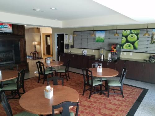 a restaurant with tables and chairs and a fireplace at La Quinta by Wyndham Atlanta Union City in Union City