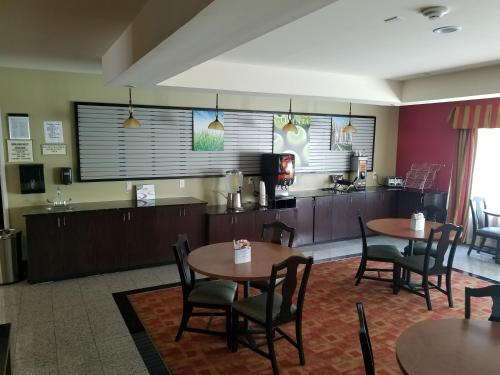 a restaurant with tables and chairs and a kitchen at La Quinta by Wyndham Atlanta Union City in Union City
