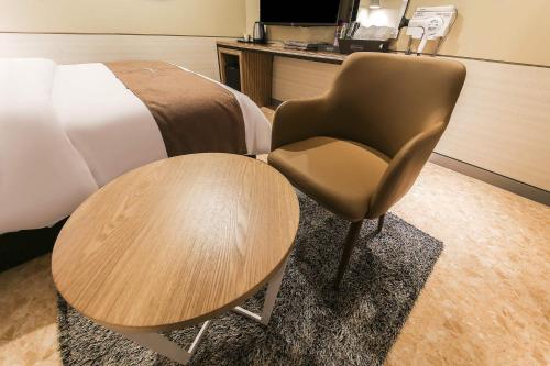 a room with a bed and a chair and a table at Docking Hotel in Gimpo