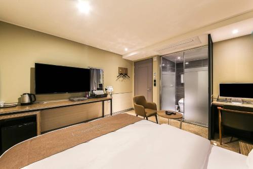 a hotel room with a bed and a flat screen tv at Docking Hotel in Gimpo