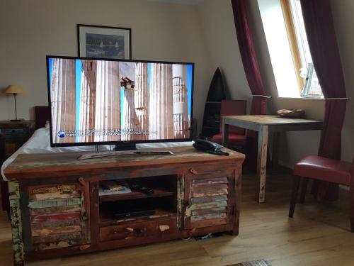 a living room with a flat screen tv on a wooden entertainment center at Seeblickstudio 2.33 im Seehof Bansin in Bansin