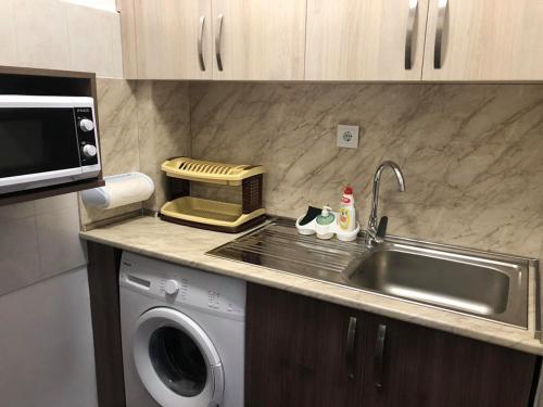 a kitchen with a sink and a washing machine at Вила Мечта in Starozagorski Bani