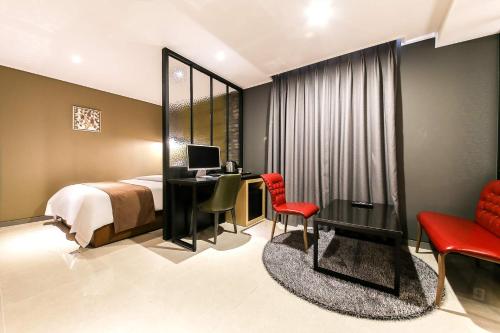 a bedroom with a bed and a desk with a computer at Docking Hotel in Gimpo
