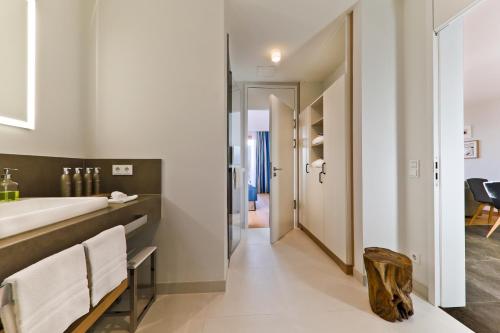 a bathroom with a large sink and a mirror at Upstalsboom Family Suiten und Lofts in Wyk auf Föhr