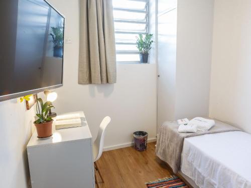 a small room with a bed and a television at Apartamento com quintal em Alto de Pinheiros in Sao Paulo