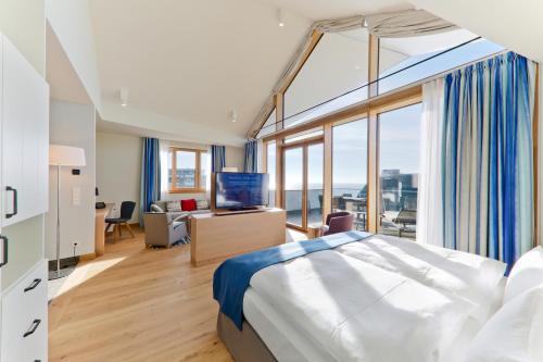 a hotel room with a bed and a large window at Upstalsboom Family Suiten und Lofts in Wyk auf Föhr