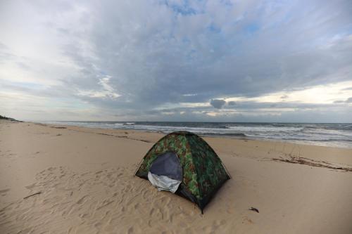a tent sitting on the beach next to the ocean at Amazing Hotel, Trương Pháp, Quang Phú, Đồng Hới in Dong Hoi