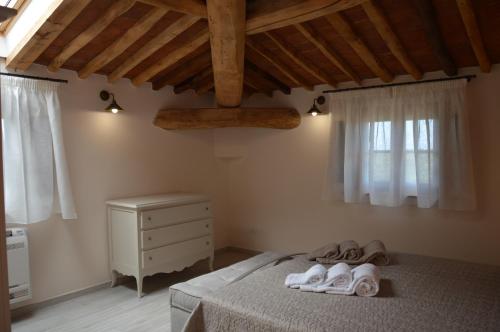 sypialnia z łóżkiem z ręcznikami w obiekcie Moraiolo Podere le Bozze con piscina WI-FI w mieście Castagneto Carducci