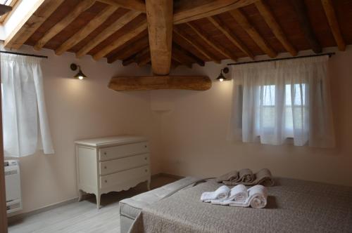 Un dormitorio con una cama con toallas. en Moraiolo Podere le Bozze con piscina WI-FI, en Castagneto Carducci