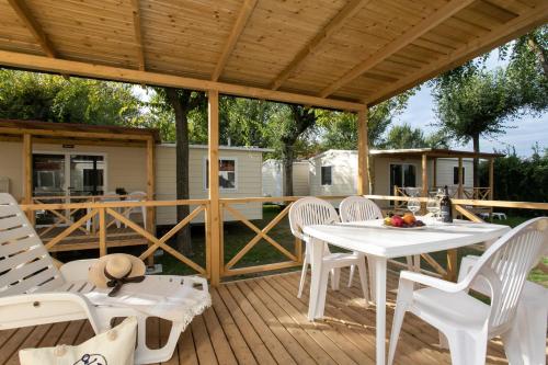 a patio with a white table and chairs on a deck at Camping Klaus in Cavallino-Treporti