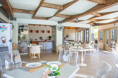 a restaurant with tables and chairs in a room at Villa Mare Monte ApartHotel in Malia