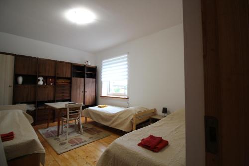 1 dormitorio con 2 camas, mesa y ventana en Dangus en Ramučiai