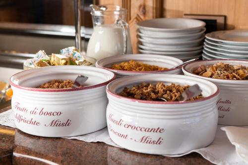 a group of four dishes of food on a counter at Hotel Garni Soreie in Pozza di Fassa