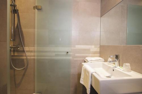 a bathroom with a sink and a shower at Golden Tulip West Ende in Helmond
