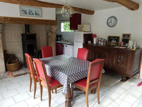 een keuken met een tafel en stoelen en een keuken met een fornuis bij Les Gites de la Renardière in Gueures