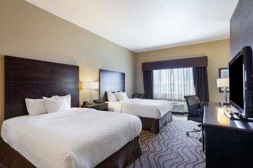 a hotel room with two beds and a flat screen tv at La Quinta by Wyndham Meridian / Boise West in Meridian