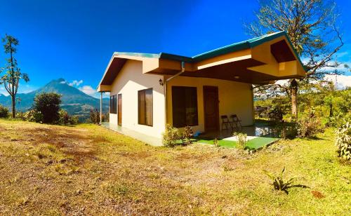 uma pequena casa no topo de uma colina em Las Pavitas Cottages em La Fortuna