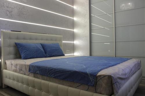 a bedroom with a large bed with a blue pillow at New luxury Apartment in the Center on Konstitution Square in Kharkiv