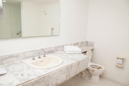 a white bathroom with a sink and a toilet at Sol Caribe Sea Flower in San Andrés