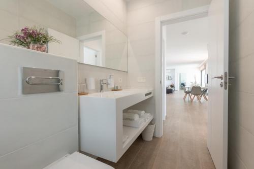 a white bathroom with a sink and a table at Sea Breeze Villas in Playa Blanca
