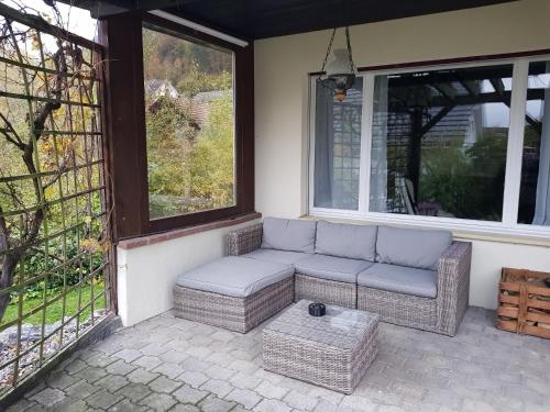a couch sitting on a porch next to a window at Gästehaus Luma in Egerkingen