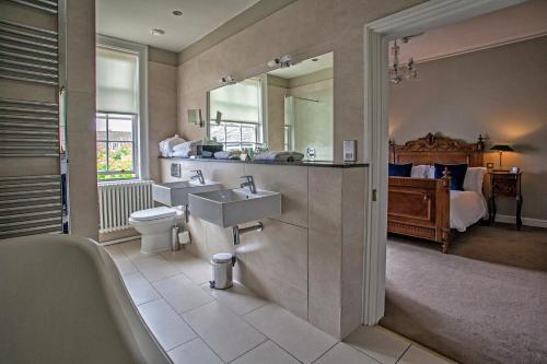 a bathroom with a sink and a toilet and a bed at Grays Court Hotel in York