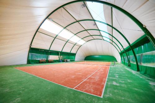 a tennis court inside of a building with a tennis racket at Ośrodek Ukazia in Orzechowo