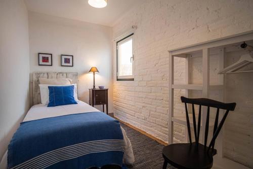 Un dormitorio con una cama azul y blanca y una silla en Casa do Largo - Litle house by the vines en Alfeiria