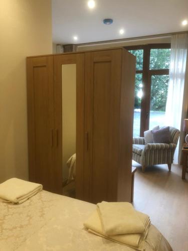a bedroom with a bed and a cabinet with a mirror at Courtyard Studio in Armagh