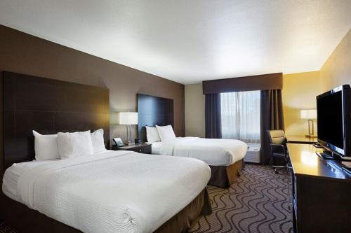 a hotel room with two beds and a flat screen tv at La Quinta by Wyndham Meridian / Boise West in Meridian